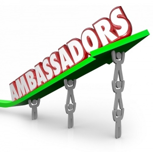 Ambassadors word in 3d red letters on an arrow lifted by people serving as diplomats or representatives from a company, organization or country